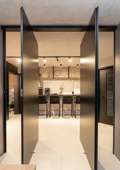 Portas pivotantes pretas que integram os ambientes da clínica