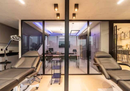 Sala de procedimentos com paredes de vidro, luz natural e vista para a cidade